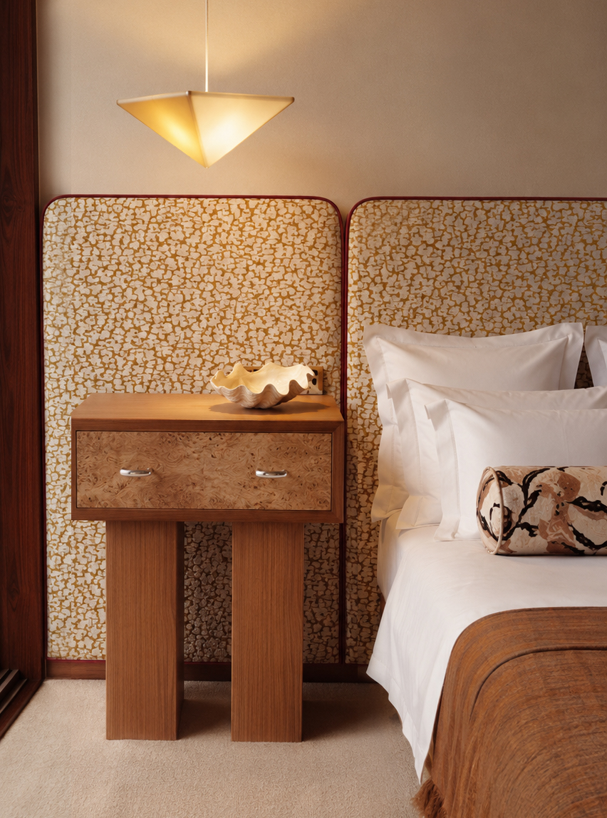 Bedroom detail with upholstered headboard and burl nightstand